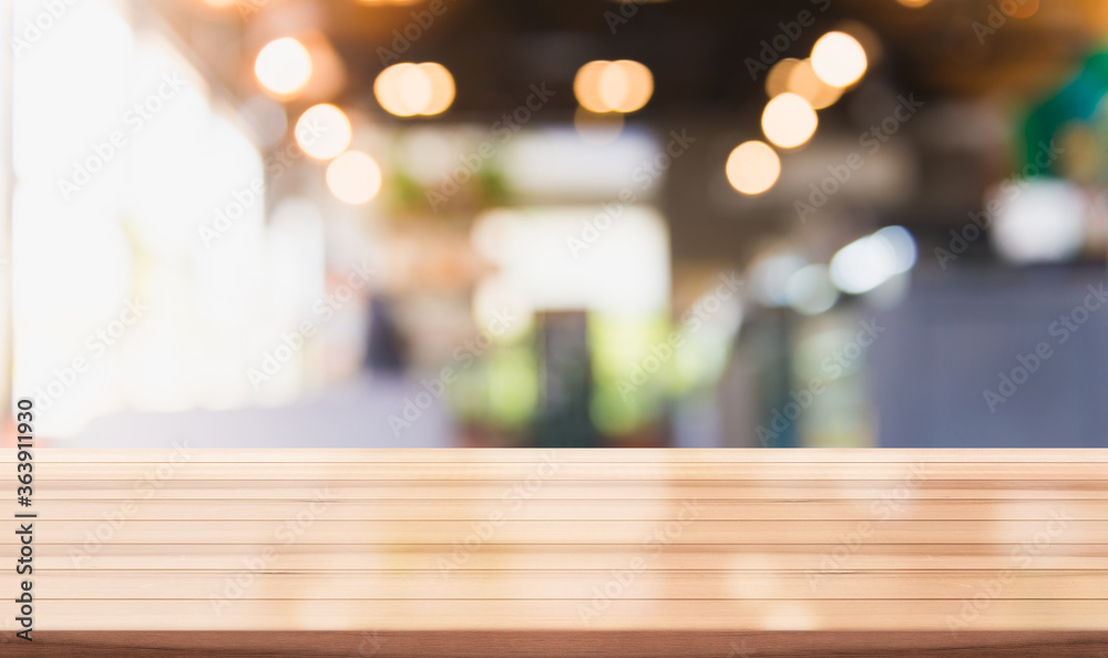 Empty wooden table top with lights bokeh on blur restaurant background