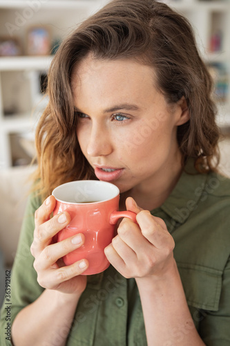 Woman holding coffee cup at home