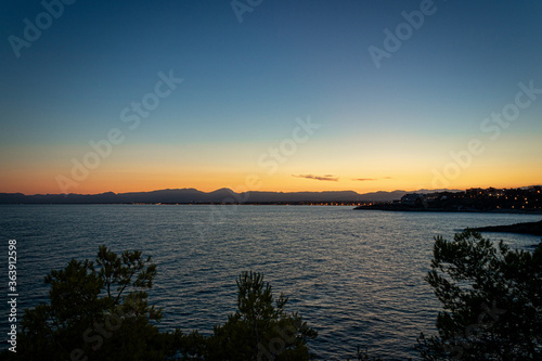 A beautiful sunset in a coast of Salou (Spain) with a blue sky and rocks