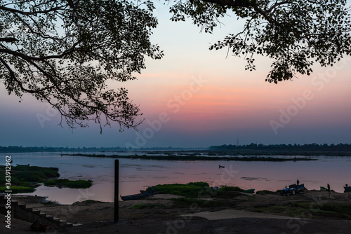 A colorful dawn over the river Narmada with sunrise at Cheepaner Ghat, Madhya Pradesh, India. © artqu