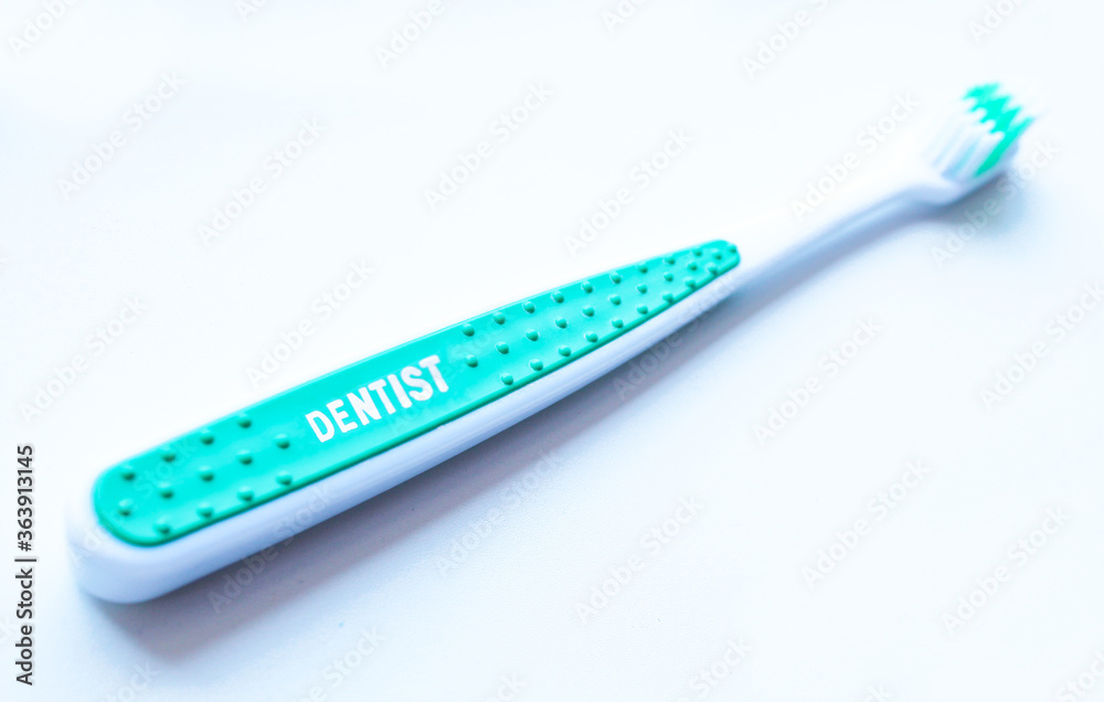 Close up tootbrush on white background with dentist word on it. Close up tootbrush on white background with dentist word on it.