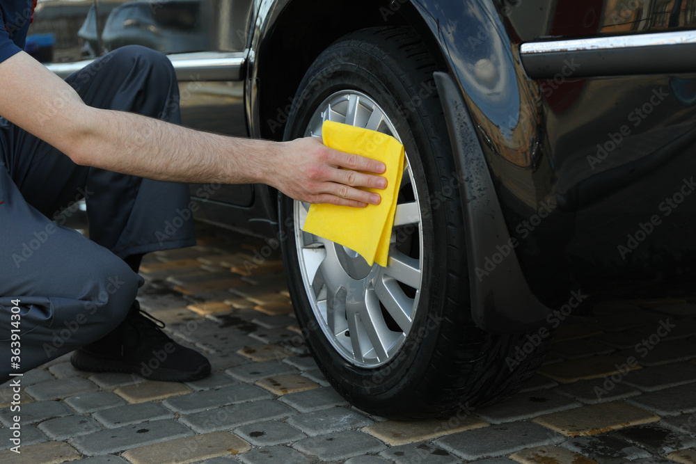 Obraz premium A man rubs a car. Car wash. Clear car concept
