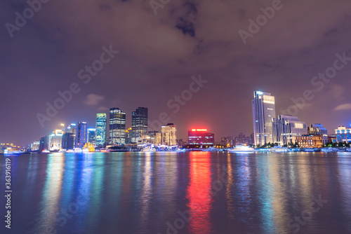 There are many tall buildings by the river in the evening. © 一飞 黄