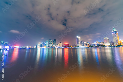 There are many tall buildings by the river in the evening.