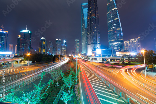 Tablou pe pânză High-rise buildings, overpasses, and heavy vehicular traffic in the city center at night
