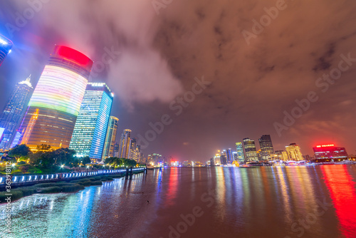 There are many tall buildings by the river in the evening.