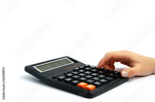 female female finger presses buttons on a large calculator white background 