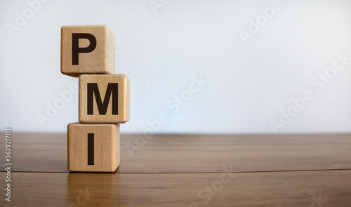 Concept word 'PMI' on cubes on a beautiful wooden table. White background. Business concept. Copy space. photo