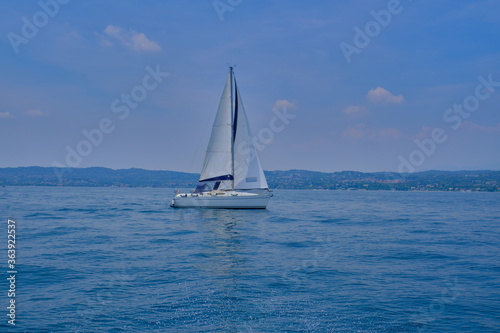 White yacht with a sail in motion