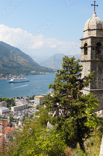 Kotor old bell tower and red roofs. View of the bay and houses with a red tiled roof. Great view from above.