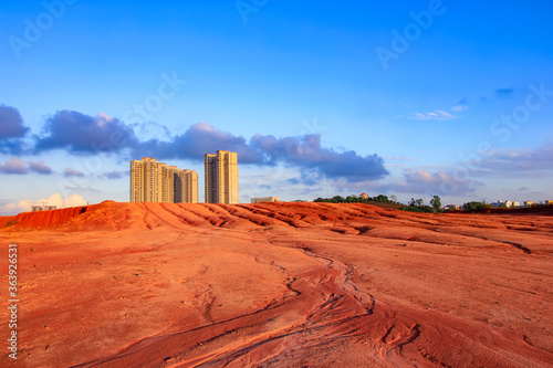 Tall buildings on red earth.