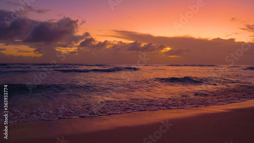 Fototapeta Naklejka Na Ścianę i Meble -  Small waves roll towards a tropical island on a sunny evening.
