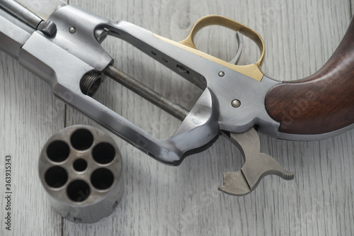 Old black powder cap and ball gun on white wooden background