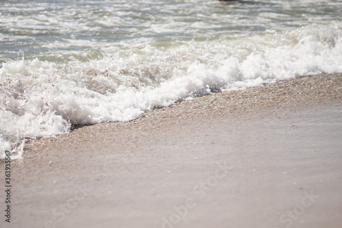 Aerial foam of sea or ocean wave crashing on sandy coast. Deserted beach. No people, vacation concept.