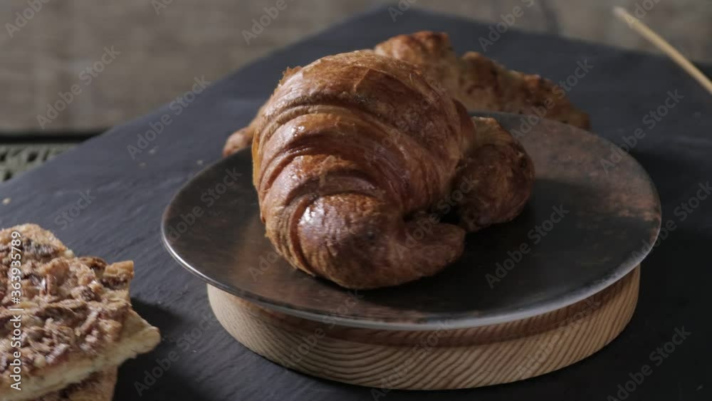 Gastronomic session of bakery, pastry. a croissant spins in the foreground, next to another croissant and other pastries. Gastronomic session of bakery, pastry. a croissant spins in the foreground, next to another croissant and other pastries.