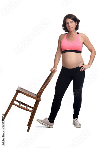 prengnant woman playing with a chair on white background