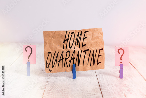 Word writing text Home Quarantine. Business photo showcasing Encountered a possible exposure from the public for observation Scribbled and crumbling sheet with paper clips placed on the wooden table photo