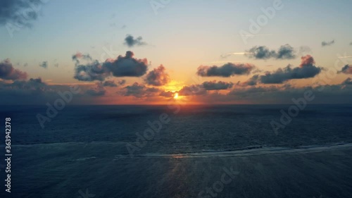 Beautiful aerial drone time-lapse of a serene ocean sunrise at Well Beach near Joao Pessoa on a warm summer morning with the water below and golden clouds on the skyline. photo