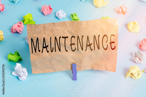 Text sign showing Maintenance. Business photo text method of preserving or maintaining someone or something Colored crumpled papers empty reminder blue floor background clothespin photo