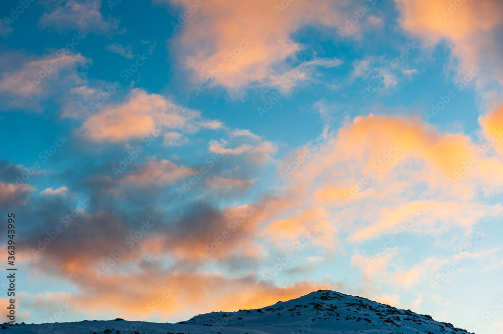 Colorful clouds above snowy mountain