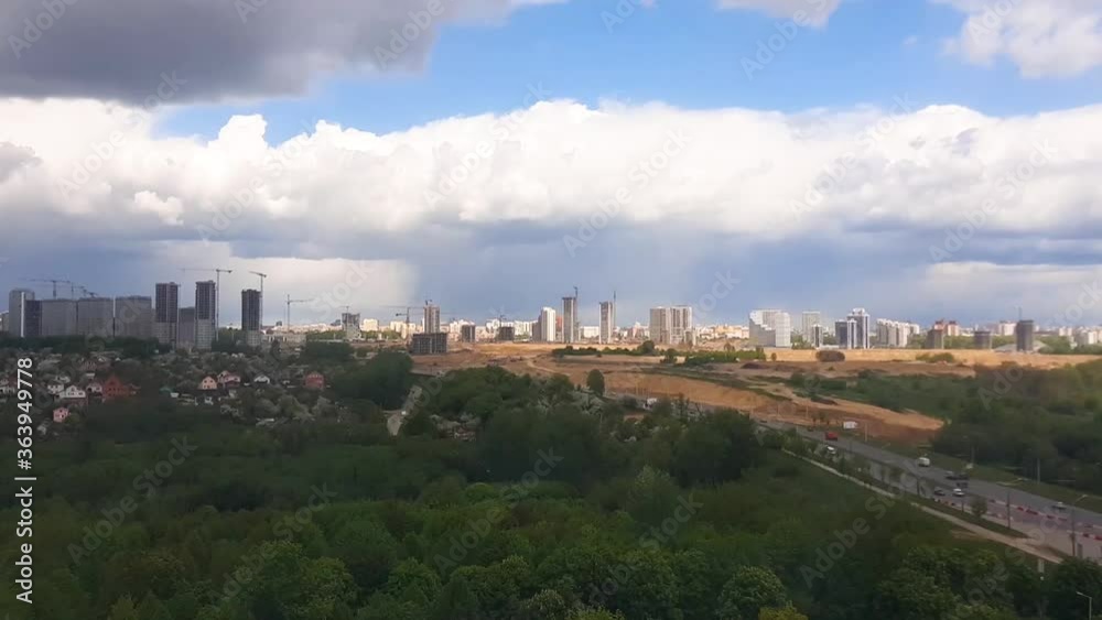 Timelaps video panorama of the city with parks from a height. Blue sky with clouds on buildings under construction. Timelaps video panorama of the city with parks from a height. Blue sky with clouds on buildings under construction.
