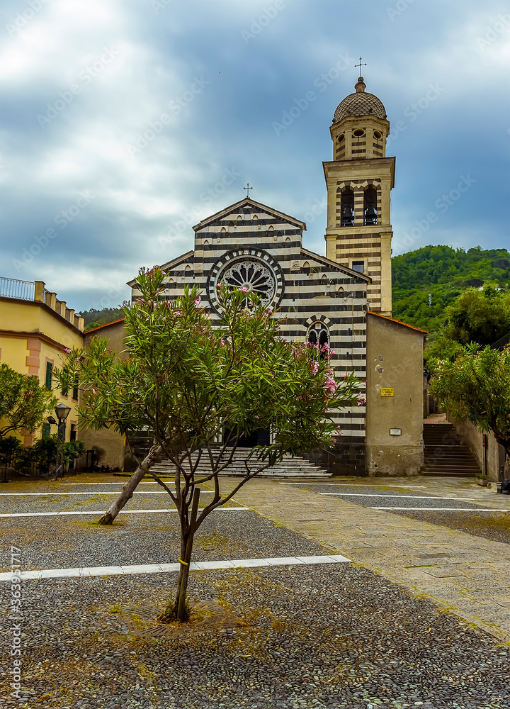 A view across the courtyard towards the striped church of Saint Andrea in the village of Levanto, Italy in the summertime A view across the courtyard towards the striped church of Saint Andrea in the village of Levanto, Italy in the summertime