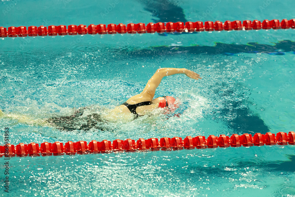 A swimmer performs the freestyle swim stroke during a swimming competition.