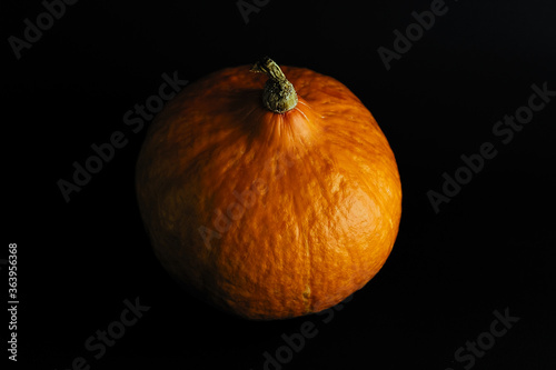 Pumpkin in dark mood. Low key photography. Seasonal food. 