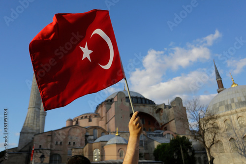 A person waves a Turkish flag in front of Hagia Sophia during a demonstration demanding the conversion of the city's iconic museum back into a mosque in Istanbul, Turkey.