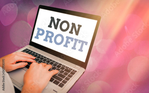 Writing note showing Non Profit. Business concept for an activity not making or conducted primarily for a profit Modern gadgets white screen under colorful bokeh background photo