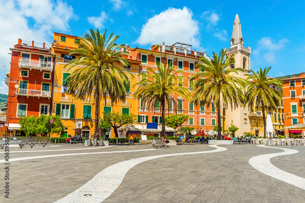 Fototapeta premium Wavy paving draws you towards the church and colourful buildings in the central square in Lerici, Italy in the summertime
