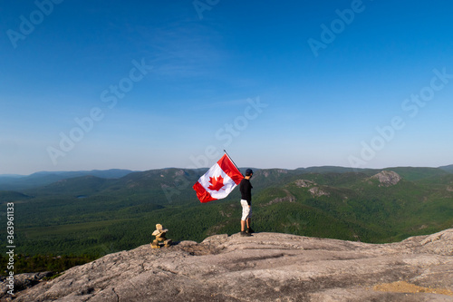 Young man holding a Canadian flag on the top of 