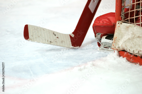 Photography Closeup of goalie's ice hockey stick and skates against white ice