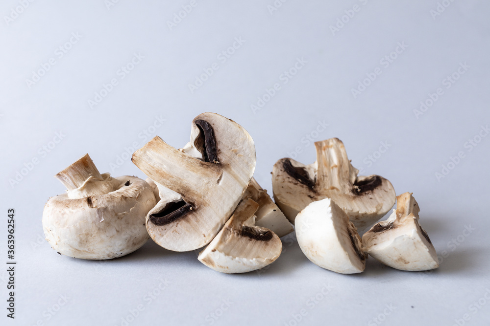 Fototapeta premium Mushrooms lies on a gray background. Champignons photographed at close range. . High quality photo