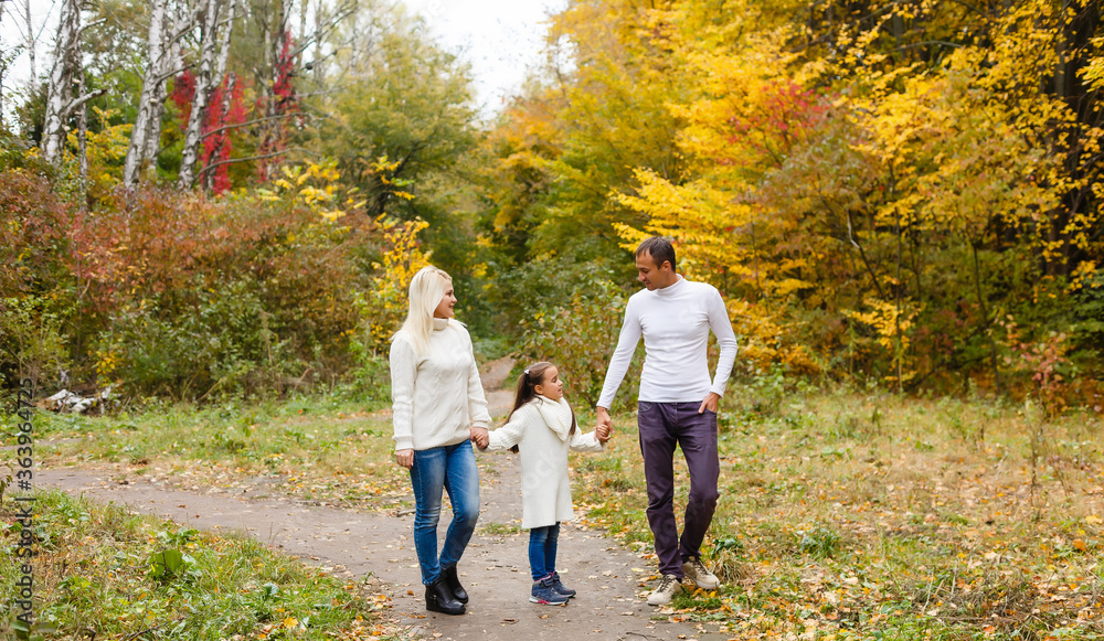 Fototapeta premium Picture of lovely family in autumn park, young parents with nice adorable daughter playing outdoors, have fun on backyard in fall, happy family enjoy autumnal nature