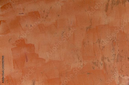 Orange painted stained weathered peeling wall.