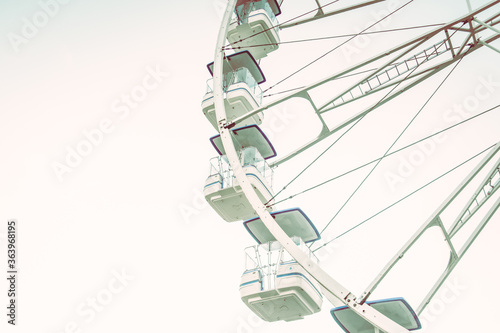 Vintage background with a part of ferris and grey sky. Beatiful background with ferris. Light, grey, white, sky, ferris wheel. Vintage style.