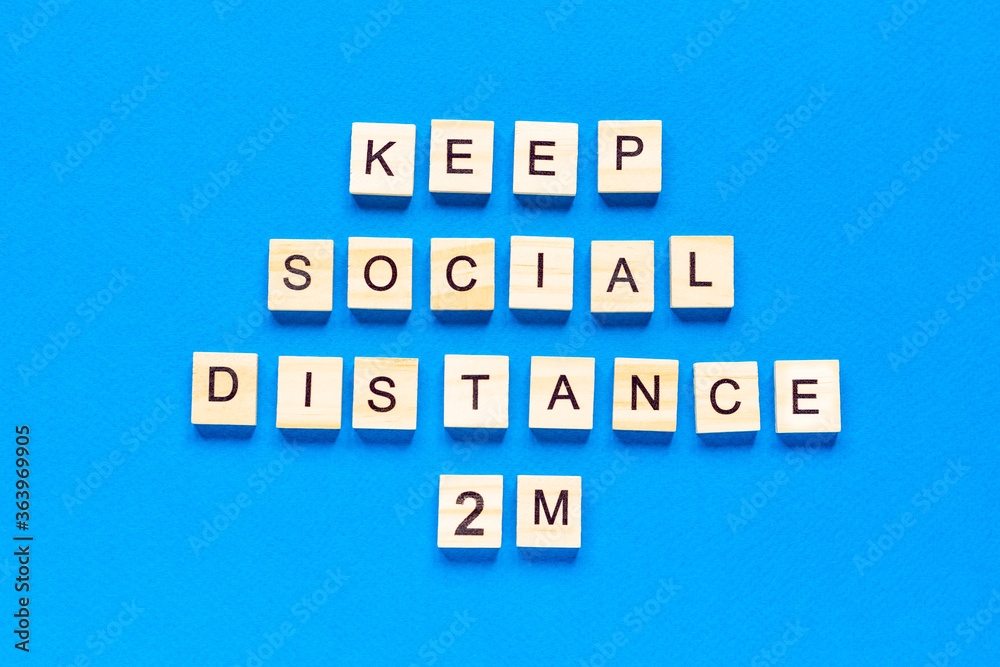 Words keep social distance 2 m. Wooden inscription on a blue background. Information sign of keep social distance 2 m from blocks. top view, Words keep social distance 2 m. Wooden inscription on a blue background. Information sign of keep social distance 2 m from blocks. top view,