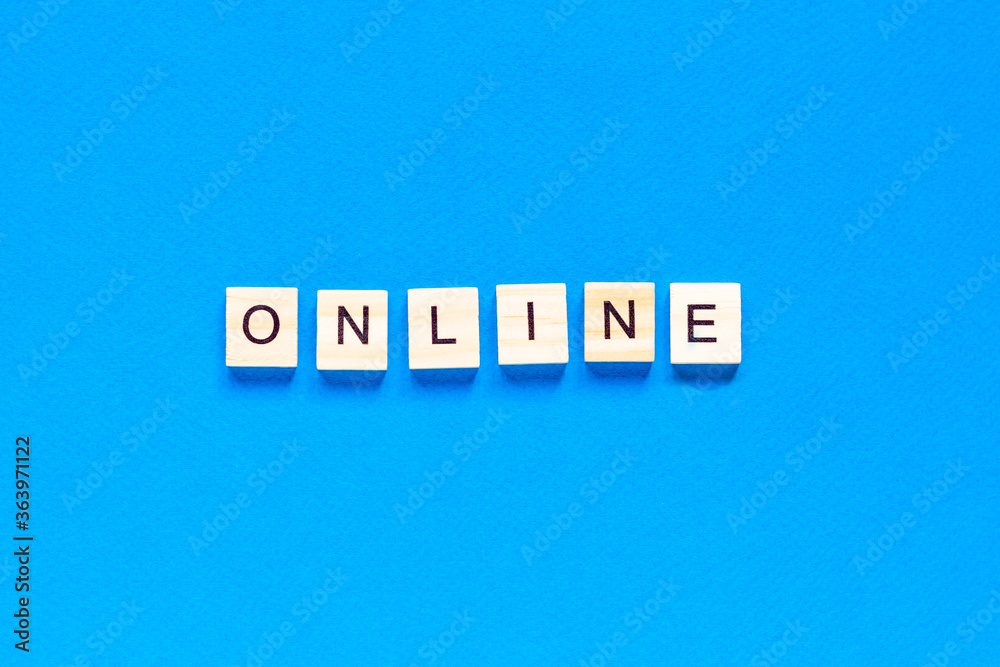 Word Online made with wooden letterpress cubes on blue background. ONLINE written on wood cubes. Conceptual. Expanding business online. Word Online made with wooden letterpress cubes on blue background. ONLINE written on wood cubes. Conceptual. Expanding business online.