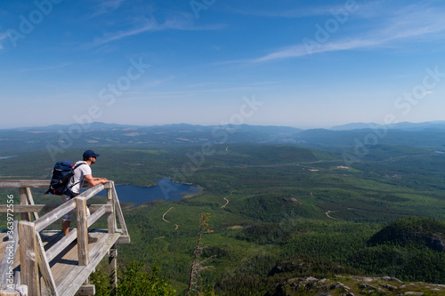 Hiker admiring the beautiful view from the top of the mont-du-lac-des-cygnes (Swan lake mountain) in Charlevoix, Quebec