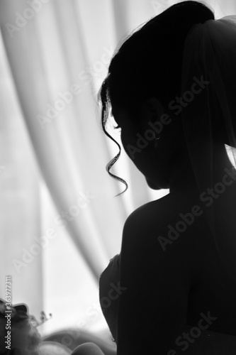 Fotografie A beautiful silhouette of a Chinese woman reflecting on her commitment at the brink of her wedding day