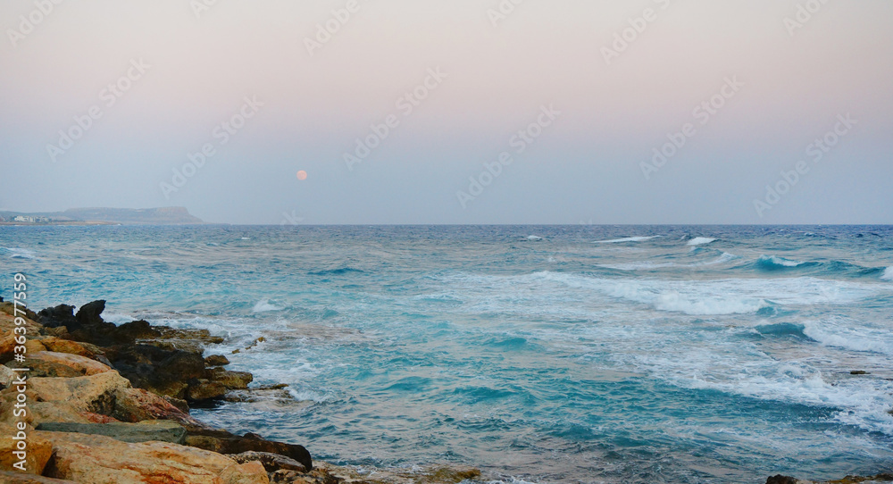 the blue waves of the sea rocky shores of Cyprus summer