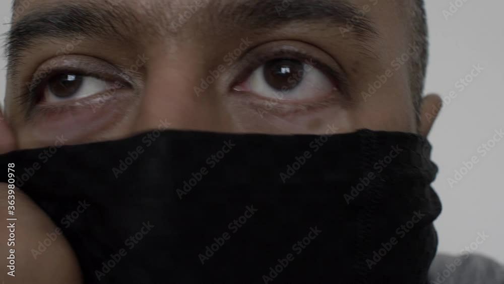 Adult UK Asian Male Putting On Snood Face Mask Indoors. Locked Off, Close Up Adult UK Asian Male Putting On Snood Face Mask Indoors. Locked Off, Close Up