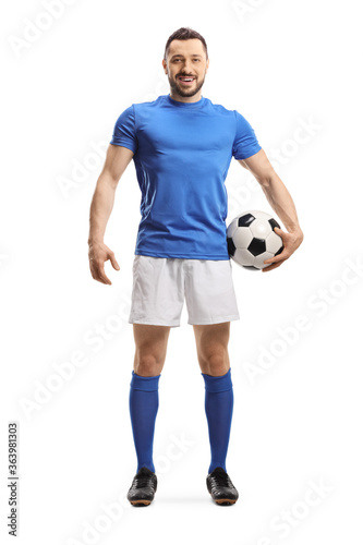 Full length portrait of a soccer player with a ball under arm posing