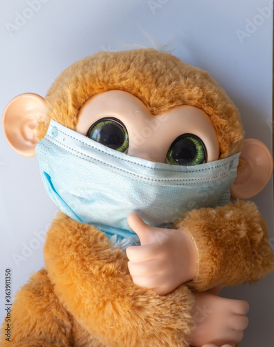 Toy monkey wearing a mask as a covid19 protection teach for kids photo