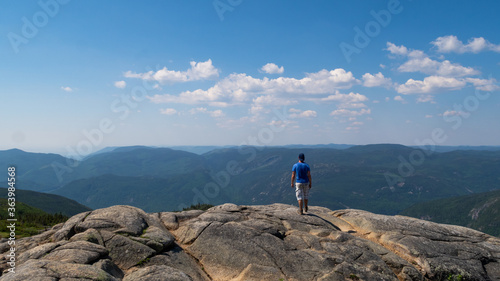 Young man standing on top of a mountain in the Grands-Jardins national park, Canada