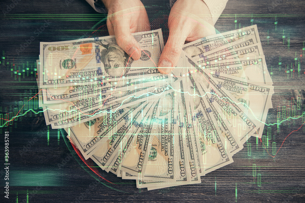 Multi exposure of financial graph drawing hologram and USA dollars bills and man hands. Analysis concept. Multi exposure of financial graph drawing hologram and USA dollars bills and man hands. Analysis concept.