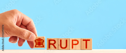 Fototapeta Naklejka Na Ścianę i Meble -  bankrupt concept. man stacks wooden blocks with a bank icon and letters in the word bankruptcy