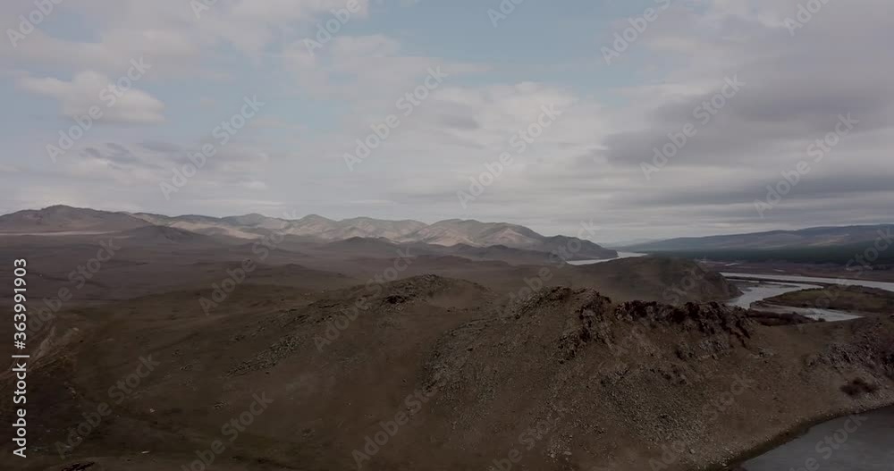 Dramatic fall dark desert steppe on a highland mountain plateau with ranges of hills on a horizon storm skyline. Aerial view of river and hills in Siberia near the city of Ulan-Ude, Russia. 4K Dramatic fall dark desert steppe on a highland mountain plateau with ranges of hills on a horizon storm skyline. Aerial view of river and hills in Siberia near the city of Ulan-Ude, Russia. 4K