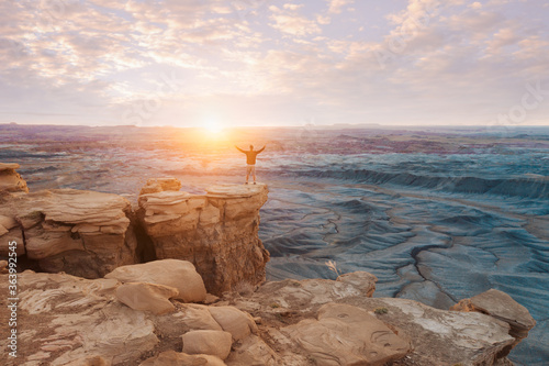 Canvas Print Man stands triumphant with his hands outstretched in victory while standing on a